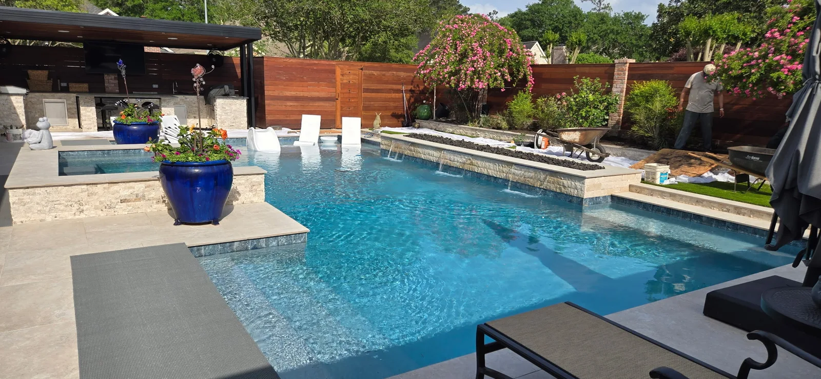 Backyard pool with sheer descent water features and an outdoor kitchen in the Greater Houston area