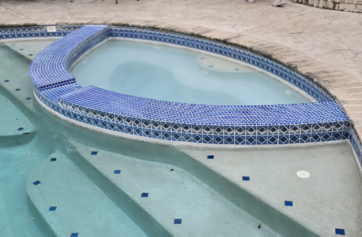 Fresh waterline tile installed along a pool edge after tile replacement